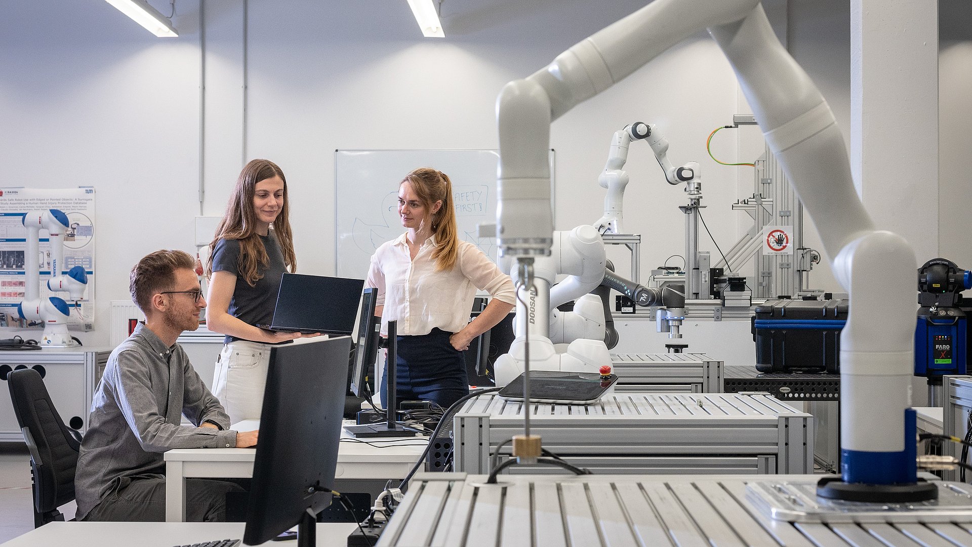 Wissenschaftlerinnen und Wissenschaftler in einem Robotik-Labor der TUM.