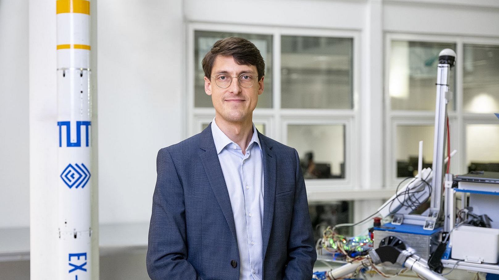Portrait von Prof. Philipp Reiss neben einem Raketenmodell