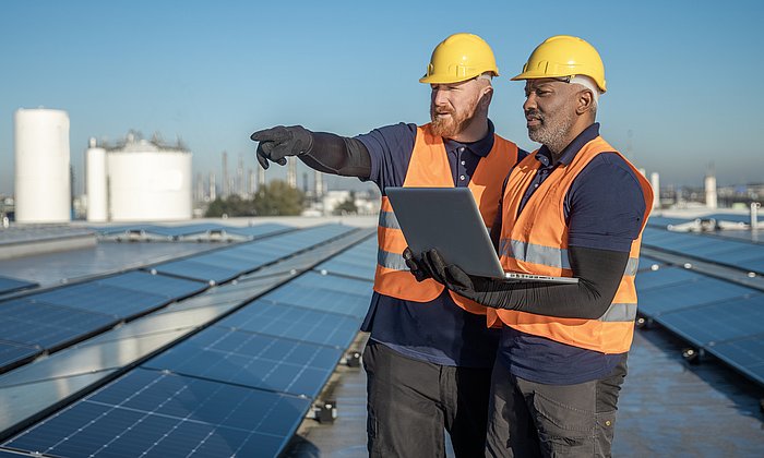 Zwei Ingenieure begutachten eine Photovoltaik-Anlage.