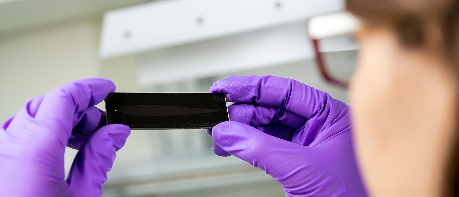 Erstautorin Julia Klüpfel mit einem der Mess-Chips im Labor des TranslaTUM.