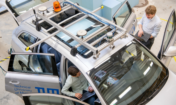 Forschende arbeiten an einem autonomen Fahrzeug