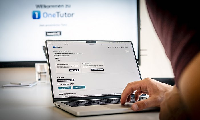 Blick über die Schulter eines Studenten, der gerade am PC sitzt und mit dem Tool OneTutor arbeitet.