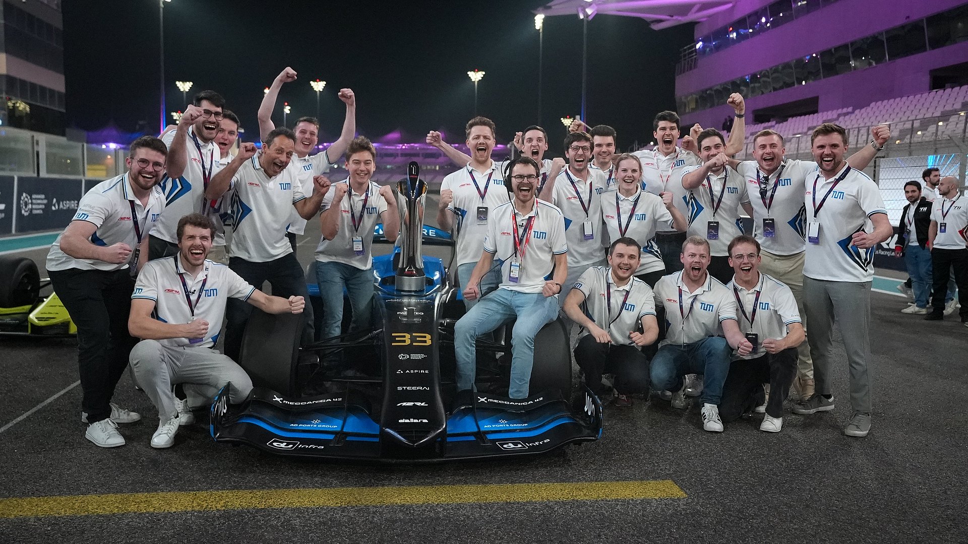 Team feiert versammelt um das Rennfahrzeug den Sieg bei der Abu Dhabi Autonomous Racing League