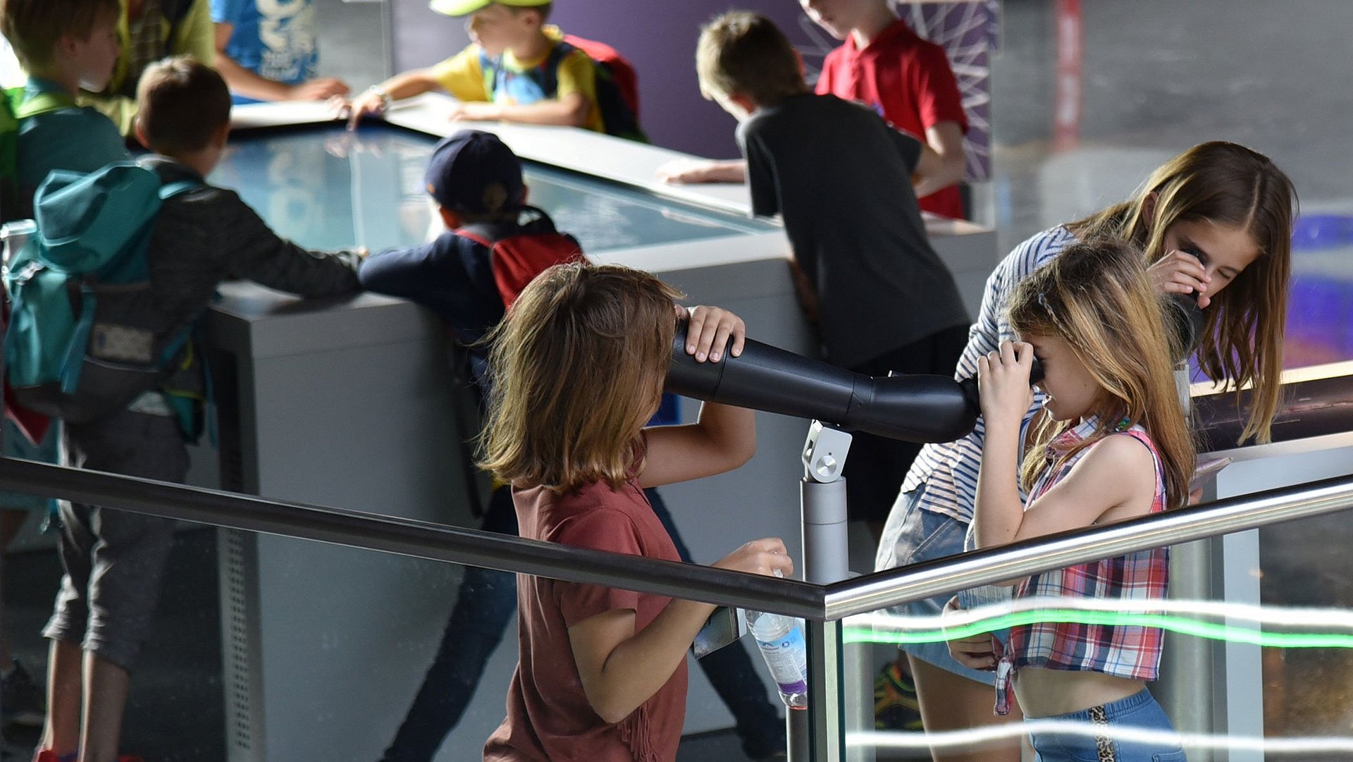 Kinder benutzen verschiedene Angebote an einem Infostand der Münchner Exzellenzcluster.