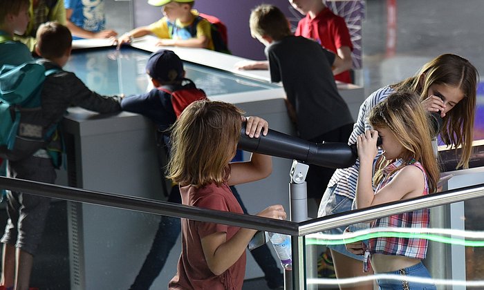 Kinder benutzen verschiedene Angebote an einem Infostand der Münchner Exzellenzcluster.