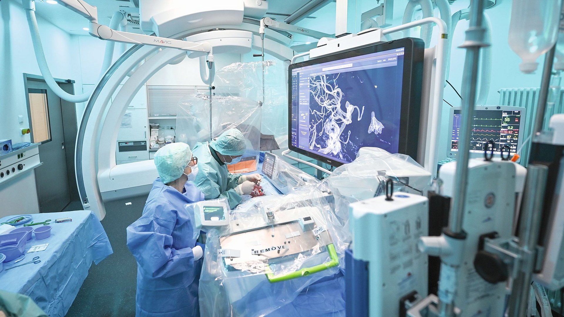 Moderner Operationssaal im Klinikum rechts der Isar, wo Ärztinnen und Ärzte gerade robotergesteuert ein Aneurysma operieren (2022)