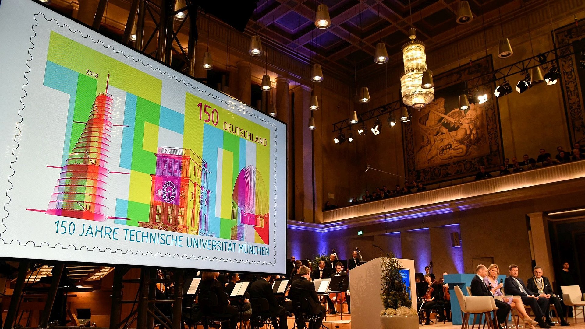 Bildschirmpräsentation der Briefmarke, die anlässlich des 150-jährigen Jubiläums der Technischen Universität München hergestellt wurde. Die Präsentation fand 2018 beim Festakt im Herkulessaal der Münchner Residenz statt. 