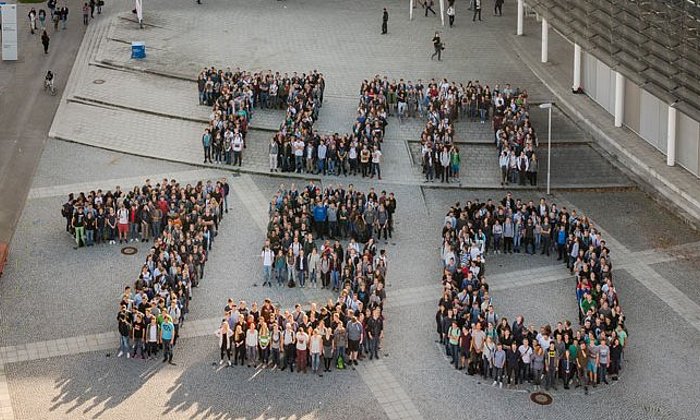 Menschen formen den Schriftzug "TUM 150"