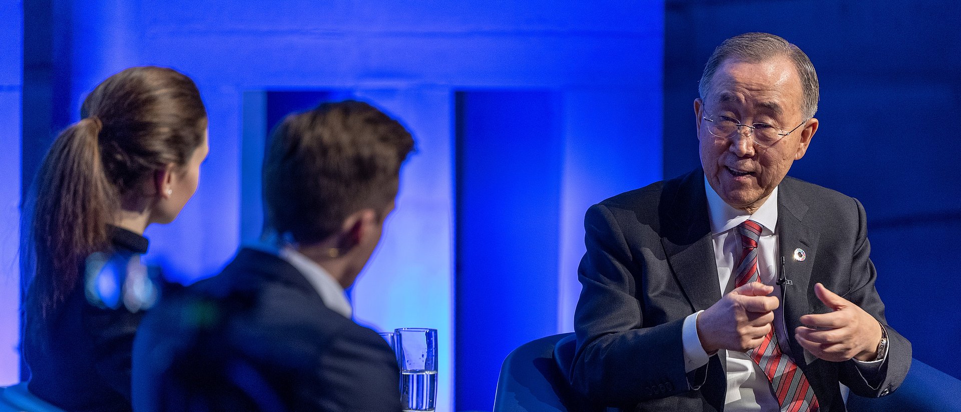 Ban Ki-moon mit Silja Wöhrle und Yannik Kaiser vom Team der TUM Speakers Series auf der Audimax-Bühne.