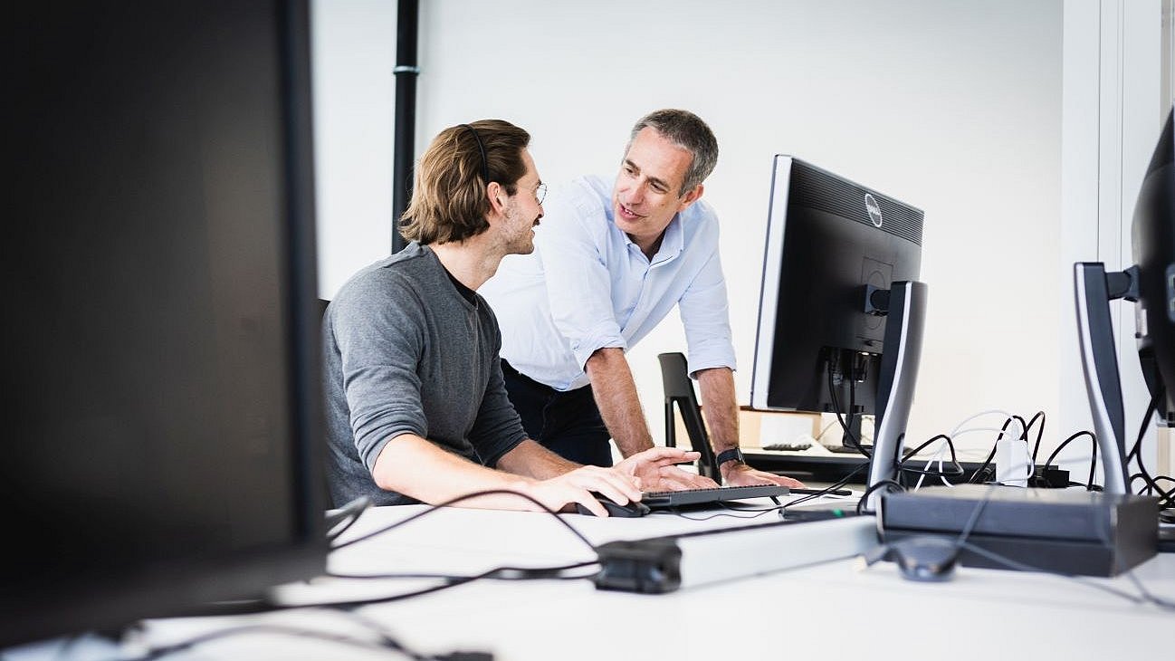 Daniel Rückert, Professor für AI in Healthcare and Medicine an der TUM, bespricht Forschungsergebnisse mit einem Mitarbeiter.