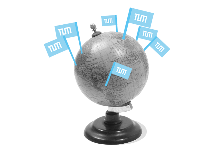 Graue Weltkugel mit hellblauen, darauf gesteckten TUM-Flaggen