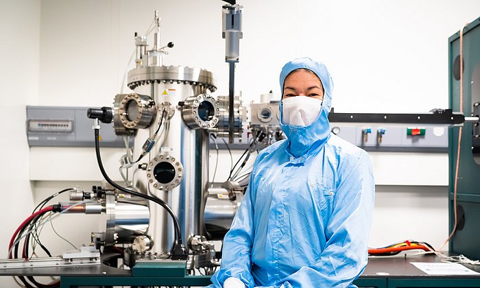 Die Professorin Eva Weig vor der Apparatur zum Aufdampfen der verschiedenen metallischen Schichten auf die Chips.
