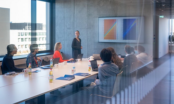 Studierende und Forschende in einem Seminarraum. 