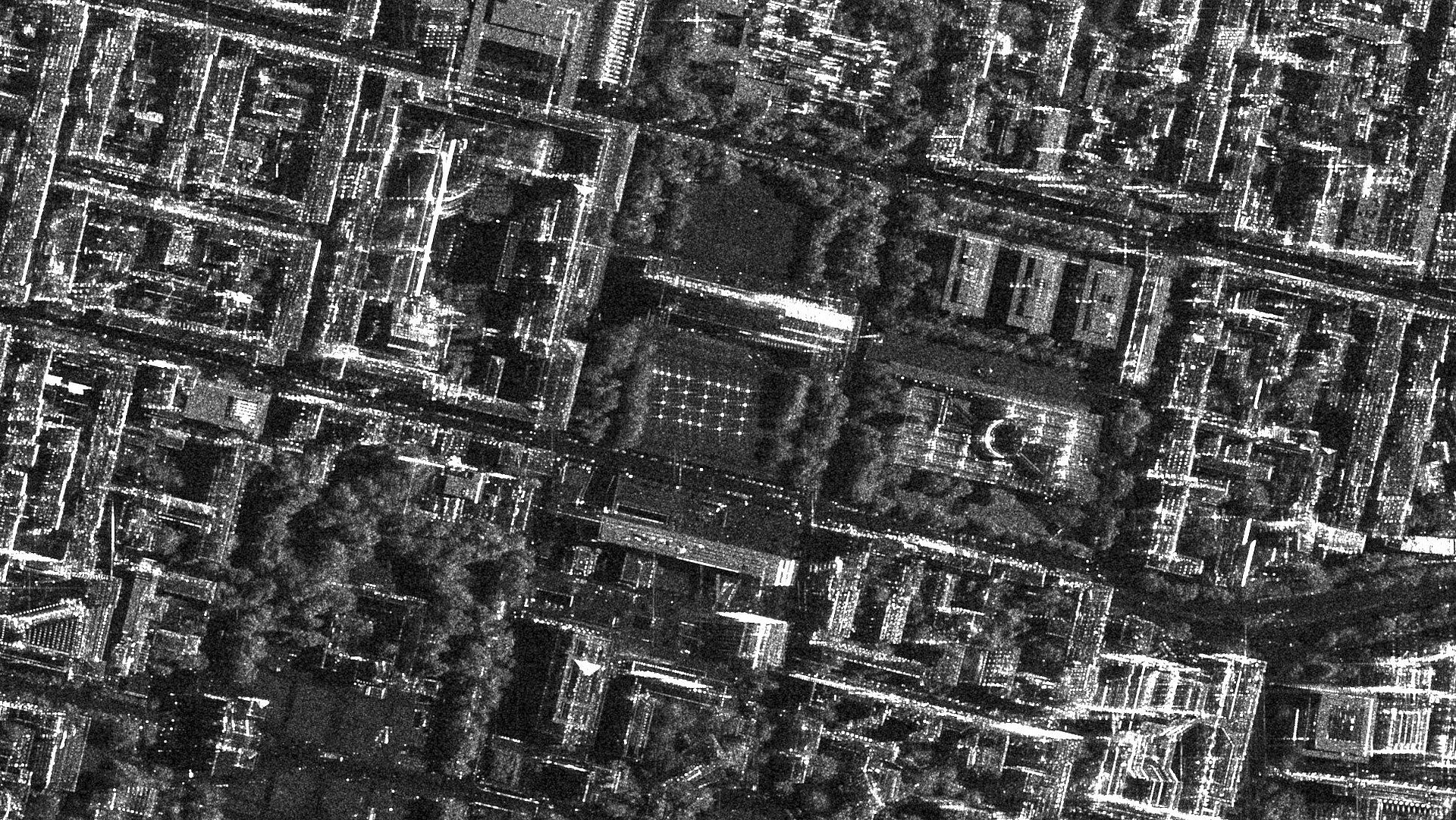 Schwarz-weißes Satellitenbild des TUM-Schriftzuges auf der südlichen Wiese der Pinakothek.