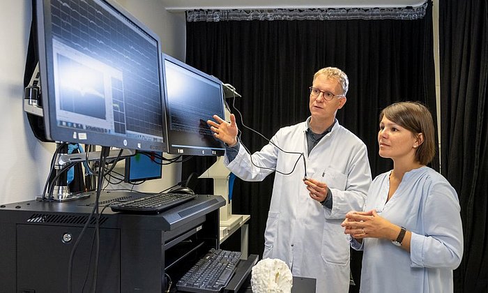 Prof. Simon Jacob und Prof. Julijana Gjorgijeva sprechen vor PC-Bildschirmen.