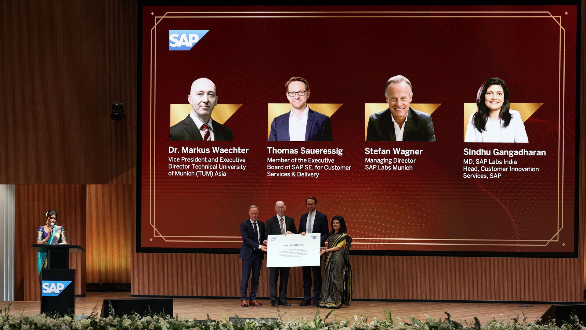 Representatives of SAP and TUM jointly present a large sheet of paper symbolizing increased cooperation.