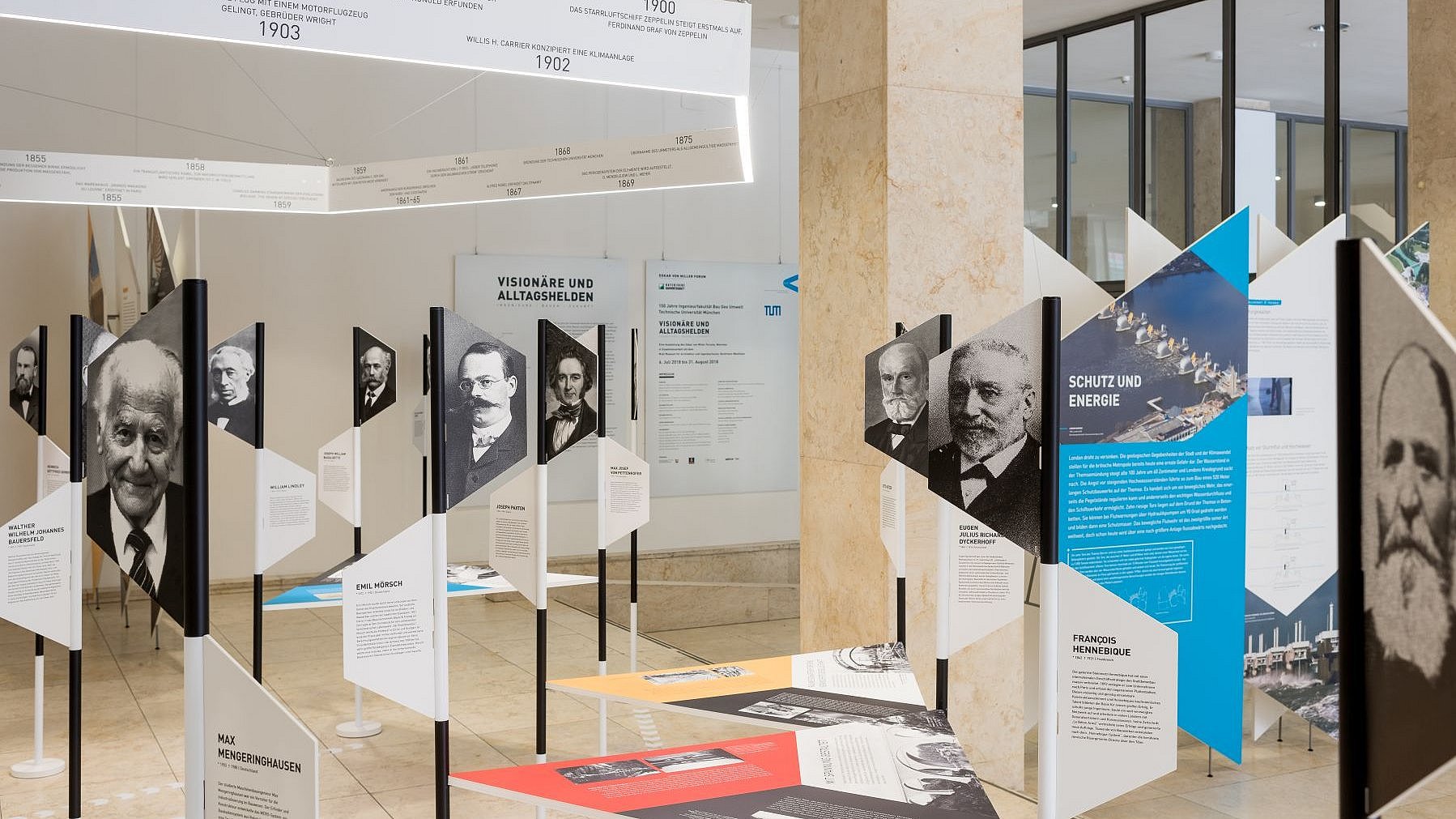 Ausstellungshalle mit Objekten der Ausstellung „Visionäre und Alltagshelden. Ingenieure – Bauen – Zukunft“, die vom 6. Juli bis 31. August 2018 in der Immatrikulationshalle der TUM zu sehen war.