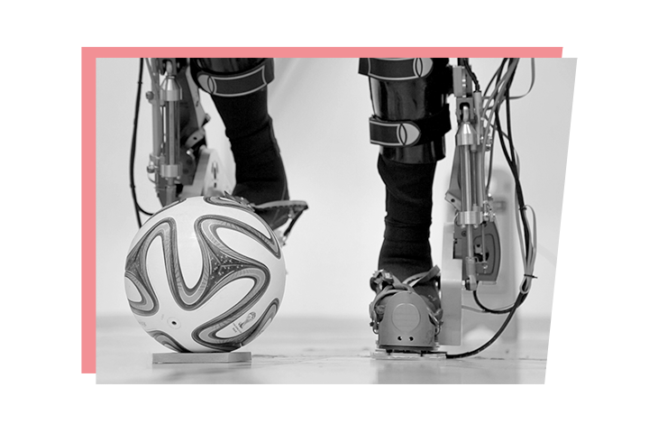 Beine im Exoskelett stoßen einen Ball