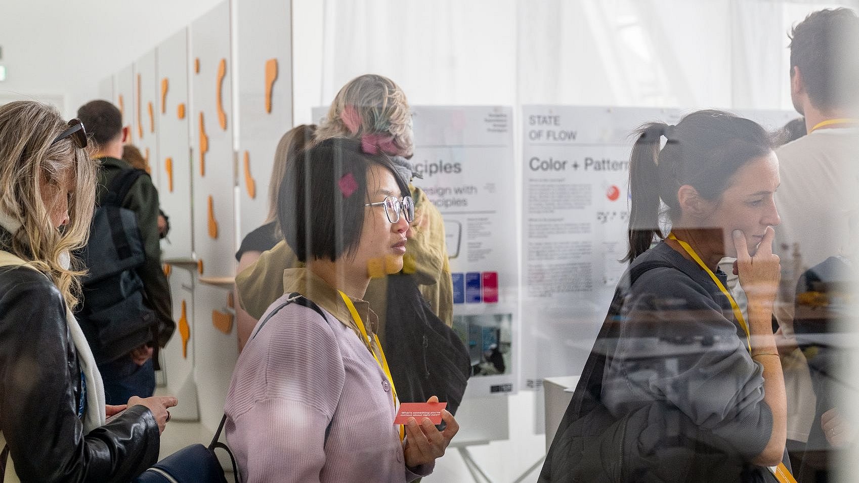 Besucherinnen und Besucher betrachten die Ausstellung zu Design-Elementen.