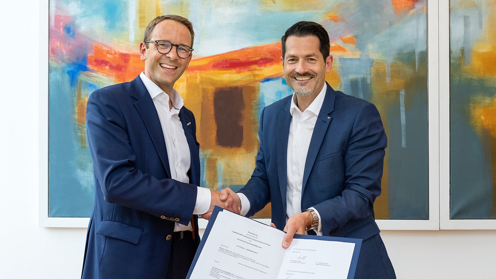 Christian Hartel, Vorstandsvorsitzender der Wacker Chemie AG (l.), und TUM-Präsident Thomas F. Hofmann mit der Urkunde zur Gründung des Instituts