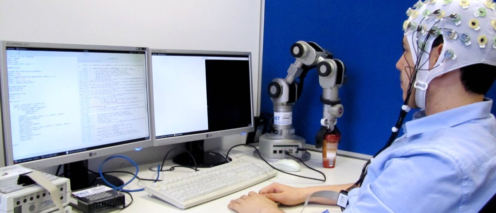 Ein Wissenschaftler ist über eine Gehirn-Rechner-Schnittstelle mit einem Rechner verbunden.