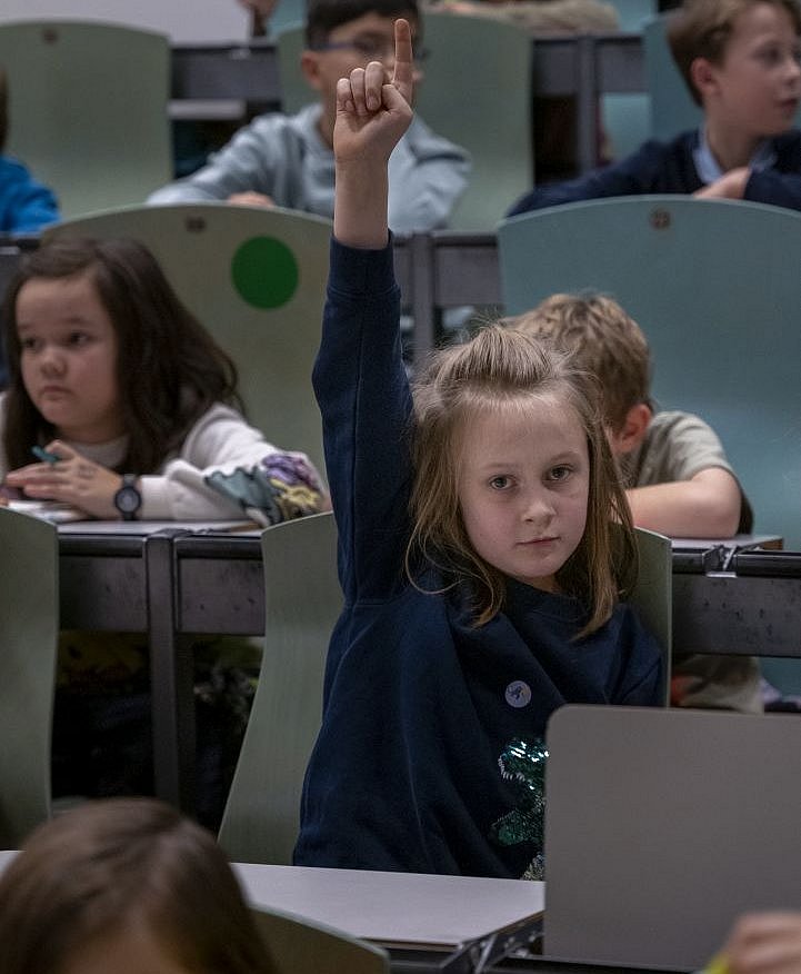 Mädchen hebt die Hand für eine Frage