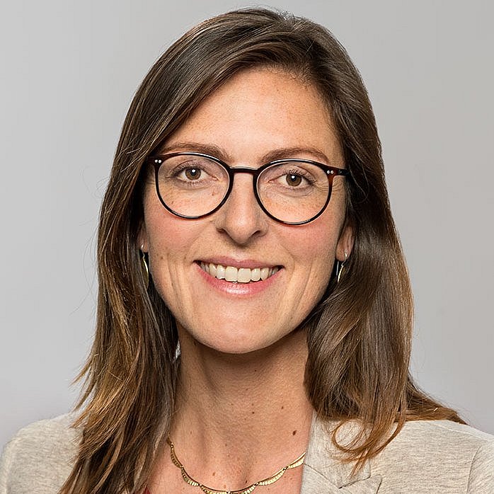 Foto einer Frau mit langen, glatten, dunklen Haaren und Brille. Sie trägt ein helles Jacket und ist die Ansprechpartnerin für das Deutschlandstipendium