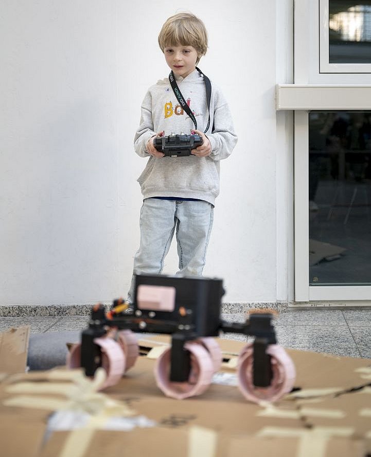 Ein Junge steuert ein Modell eines Mondrovers
