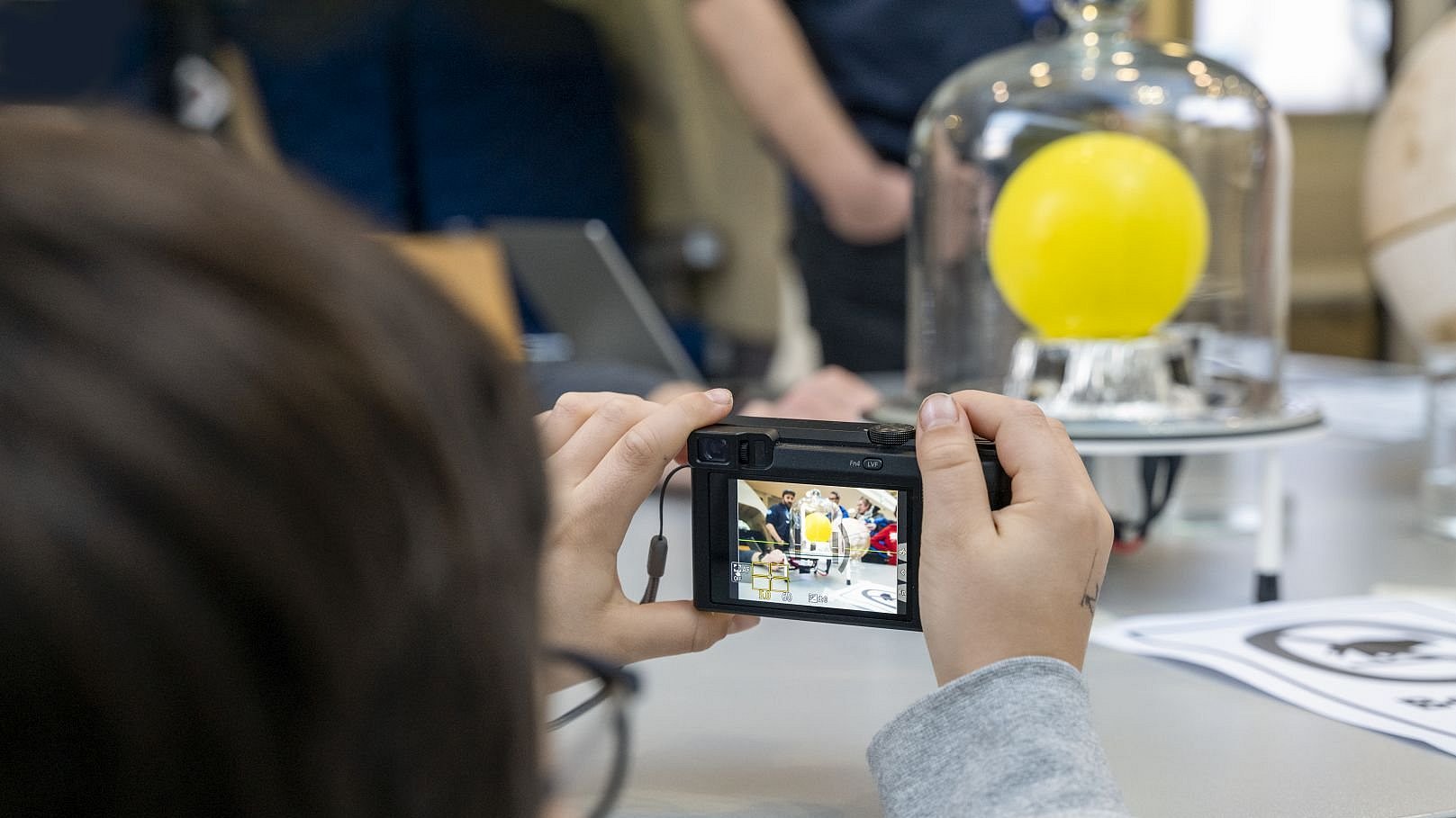 Ein Kind fotografiert ein Vakuum-Experiment