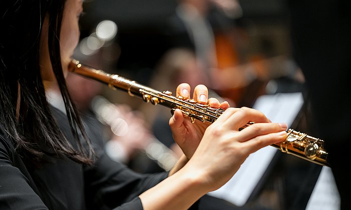 Frau mit langen glatten Haaren spielt Querflöte bei den TUM Adventskonzerten