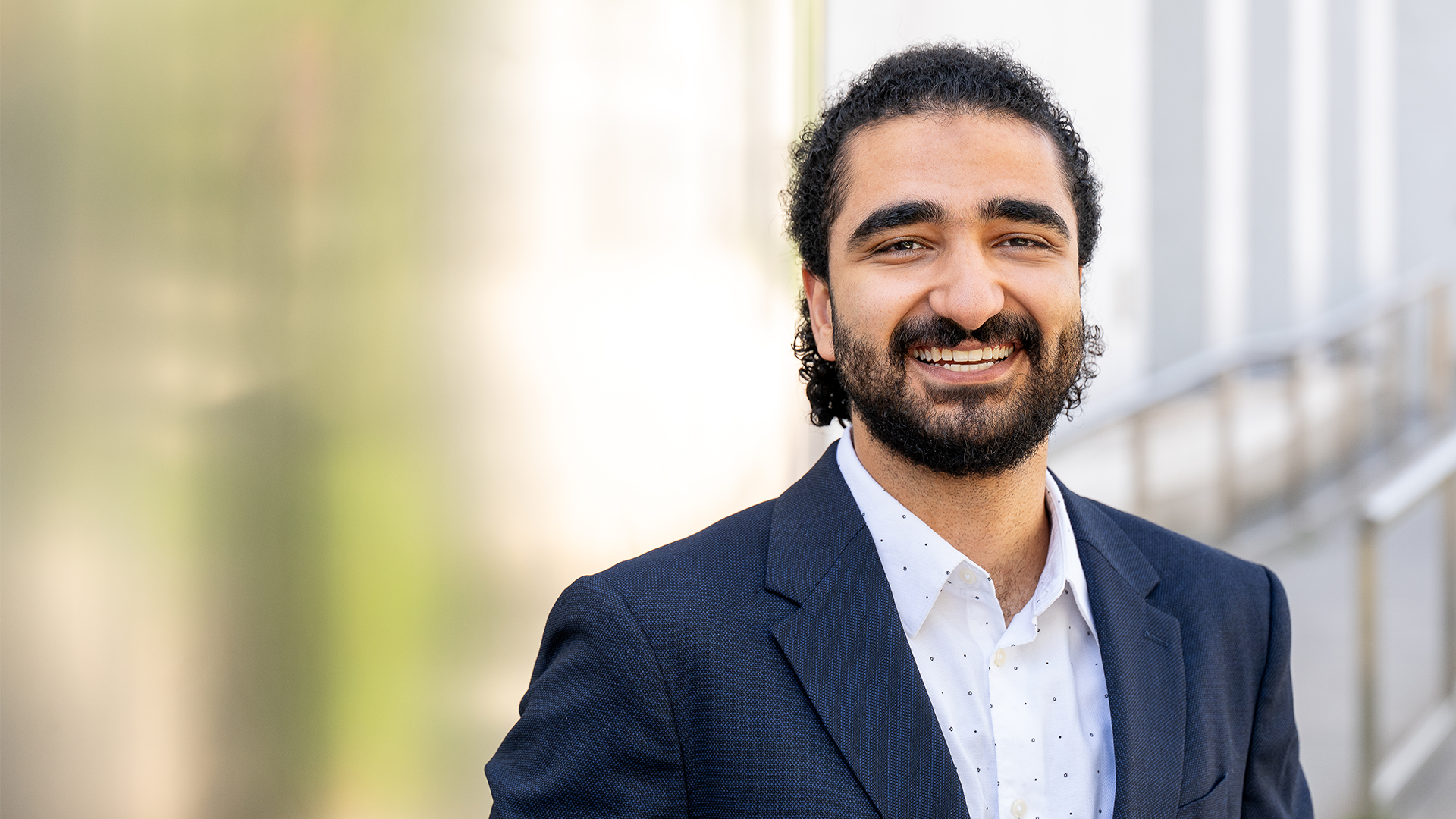 Stipendiat mit dunklen Haaren und Vollbart lächelt freundlich in die Kamera