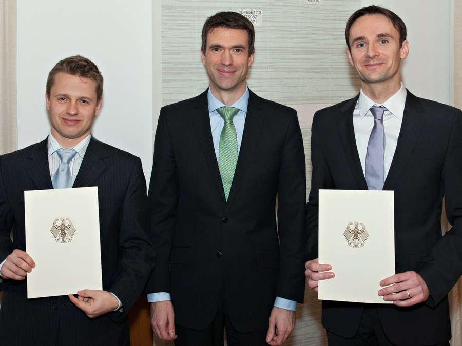 Stefan Müller (Mitte), Parlamentarischer Staatssekretär im Bundesministerium für Bildung und Forschung, übergibt Dr. Tobias Haack (links) und Dr. Julien Gagneur (rechts) eine Förderurkunde für ihr Projekt "mitOmics". (Foto: U. Benz / TUM)