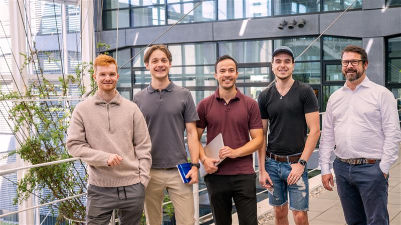 Das Bild zeigt die fünf Gründer des Startups von OneTutor im Innenhof eines Gebäudes.